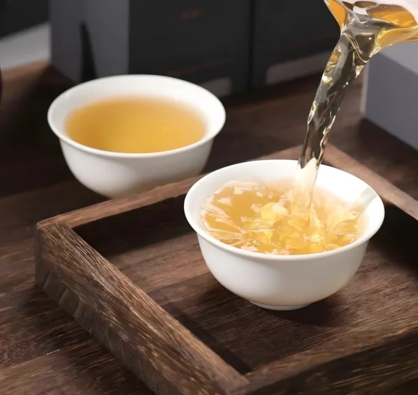 Pouring golden Tie Guan Yin Oolong tea with floral aroma, smooth taste, offering stress relief and digestion benefits