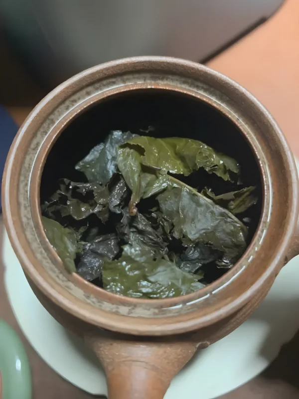 Freshly brewed Iron Goddess Oolong tea in a rustic teapot, offering smooth texture, herbal aroma, and health benefits for stress relief