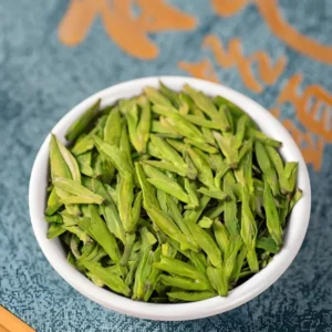 Close-up of vibrant Long Jing Dragon Well tea leaves in a bowl, showcasing detox tea detox, vital tea leaf, and slimming tea benefits.