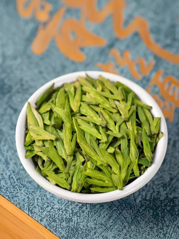 Close-up of vibrant Long Jing Dragon Well tea leaves in a bowl, showcasing detox tea detox, vital tea leaf, and slimming tea benefits.