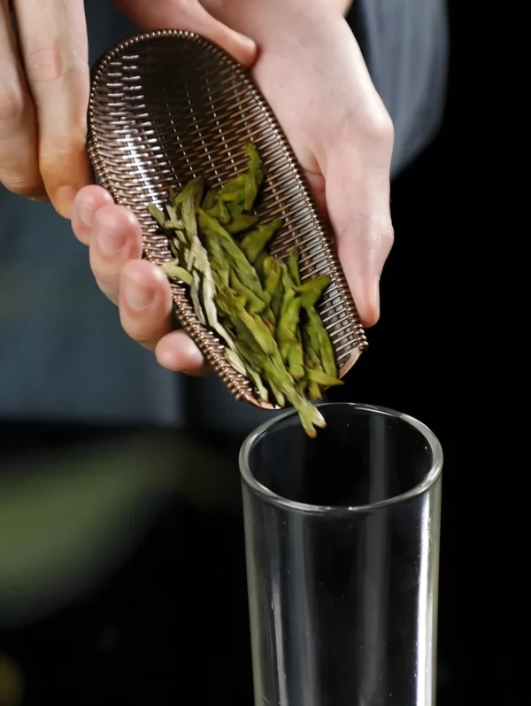 Pouring lung ching tea leaves into a glass, highlighting sugar free green tea, skinny fit detox tea, and boost immunity tea benefits.