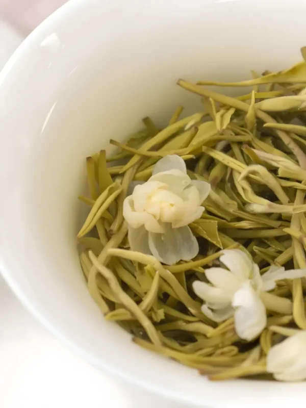 Fresh jasmine flowers steeping in green tea, showcasing the effects of jasmine green tea, ideal for jasmine Asian cuisine and tea menus.