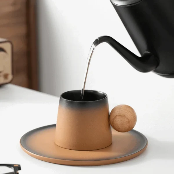 Hot water pouring into a black and brown coffee mug with a wooden handle, styled as a yellowstone coffee mug and fall coffee mugs.