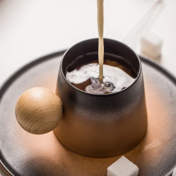 Hot water pouring into a ceramic coffee to go mug with a brown design, featuring a wooden handle, ideal as specialty coffee cups.