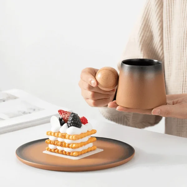 Painted ceramic coffee cups with a wide base, paired with a dessert, showcasing coffee cup art for elegant coffee moments.