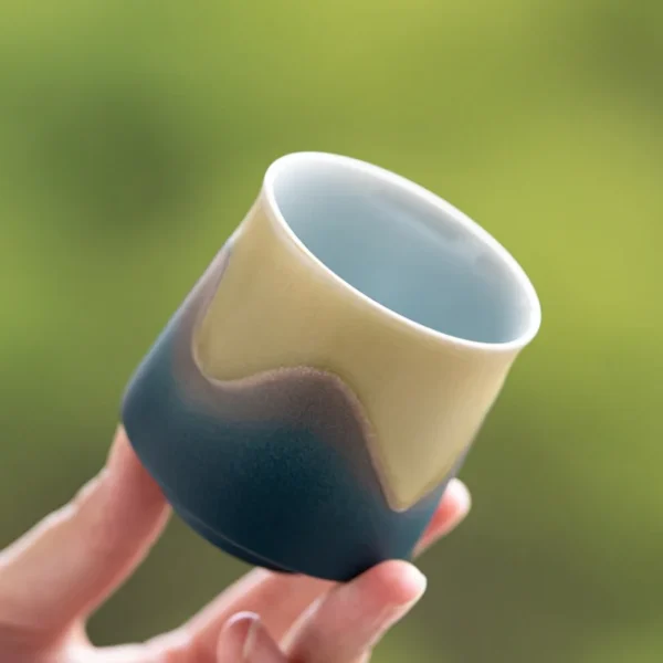 A modern blue ceramic cup featuring handcrafted artistic glaze, versatile for tea, coffee, or as a unique decor piece.