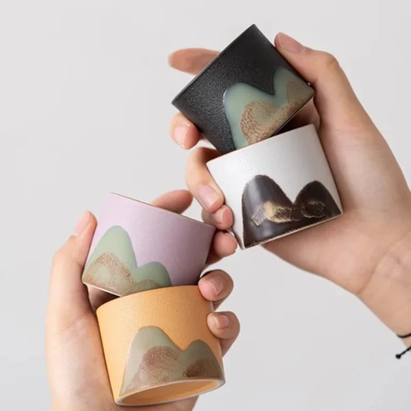 A collection of four ceramic cups featuring unique mountain-inspired patterns, perfect for gifting or enhancing tea time rituals.