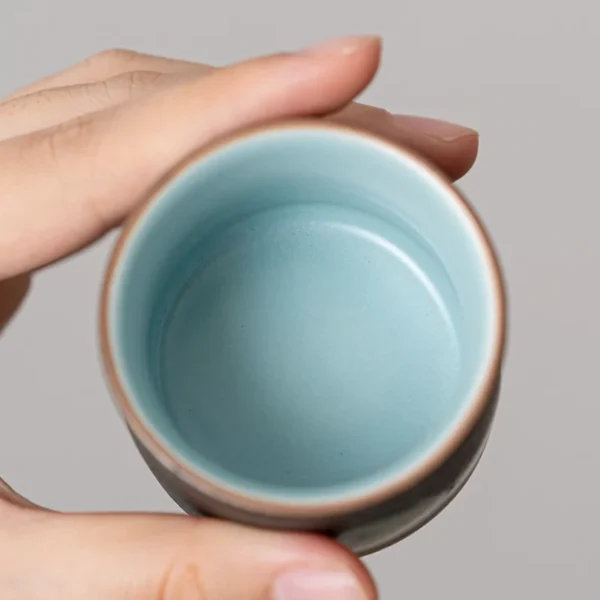 Close-up of a ceramic cup featuring a smooth sky-blue glazed interior, ideal for enhancing tea enjoyment.