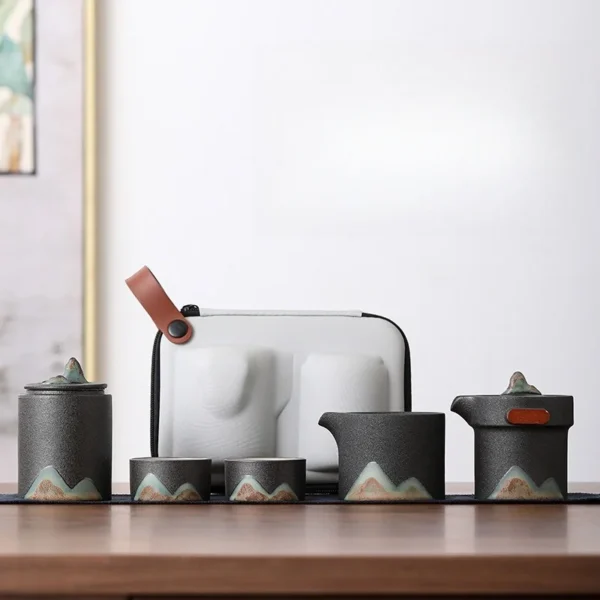 Portable black painted ceramic travel tea set with teapot, strainer, and tea caddy.