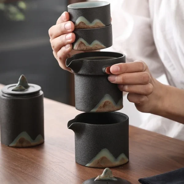 Asian tea set featuring a ceramic tea pot, ceramic tea infuser, and stackable tea mug and infuser for easy storage.