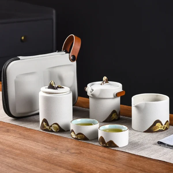 Portable travel tea set featuring a ceramic tea pot strainer, Chinese porcelain mugs, and a compact carrying case