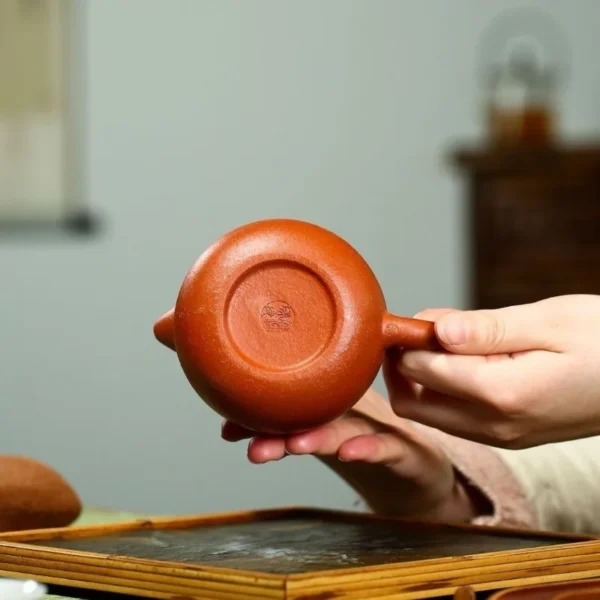 Close-up view of the authenticity mark on the handmade Yixing purple clay teapot, crafted from Jiangpo-ni clay.
