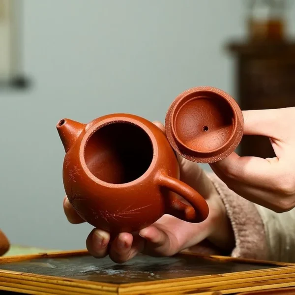 The Yixing bamboo-engraved purple clay teapot lid ensures a user-friendly, airtight fit for efficient brewing and preserving tea aroma.