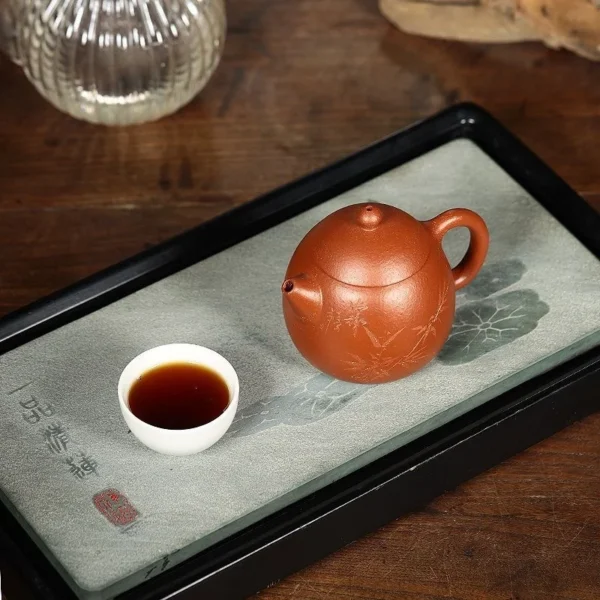 Experience elegant tea moments with this bamboo-engraved Yixing purple clay teapot, designed for sophistication and relaxation.