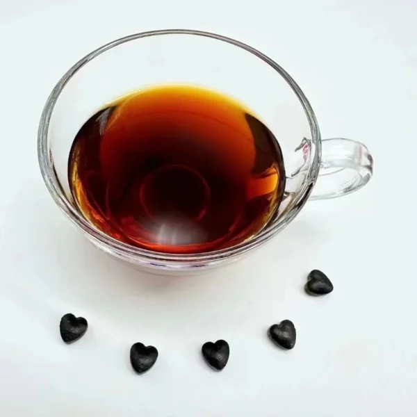 Freshly brewed Rose Pu'er tea made from heart-shaped instant tea paste, featuring deep amber color and rich, smooth flavor.