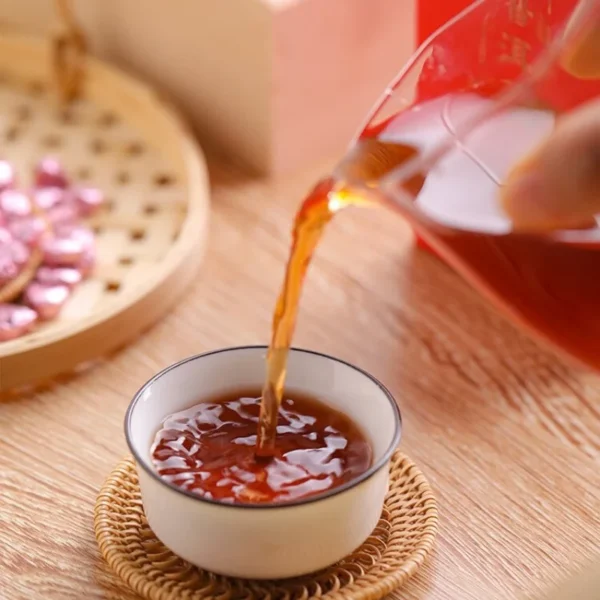 Pouring freshly brewed Rose Pu'er tea, showcasing its heart-shaped tea paste, antioxidant benefits, and rich amber hue.